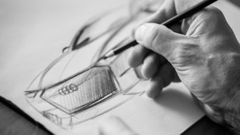 Närbild på en hand som skissar en Audi.