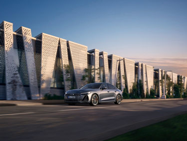 Audi A5 Sportback e-hybrid n a dynamic side view on a street with a big city in the background
