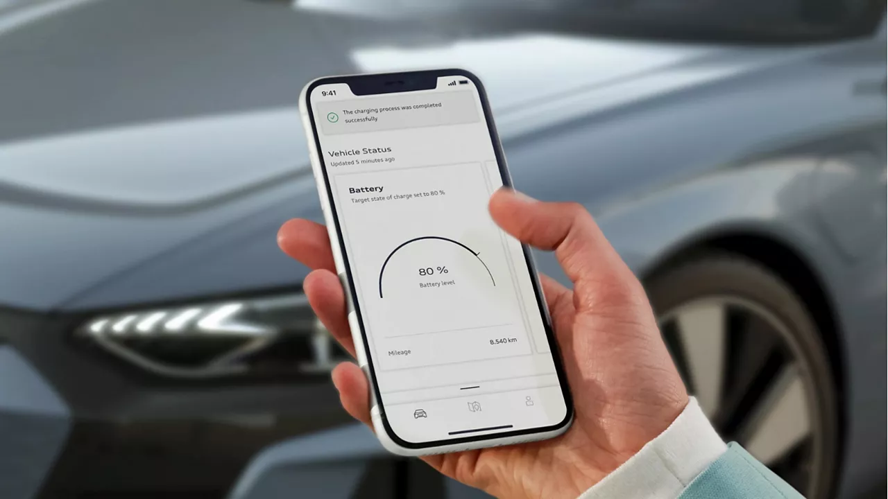 Hand holding a mobile displaying the MyAudi app on screen