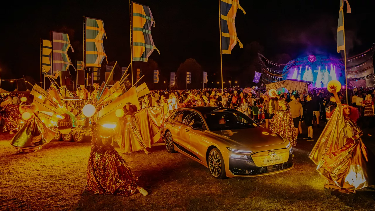 A vibrant live music performance featuring a band on stage illuminated by blue and red lights, with members playing instruments passionately.