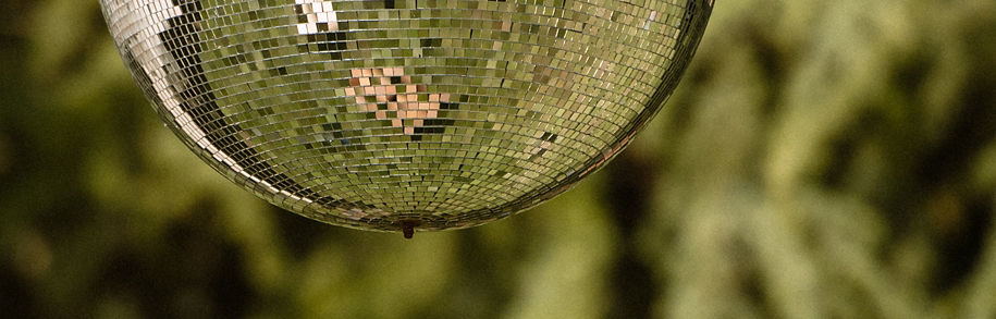 mirror sphere in the woods reflecting the sky and woodland green surroundings