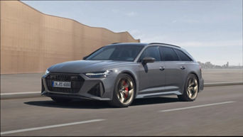 A grey Audi RS 6 Avant Performance driving on road with urban skyline in the background