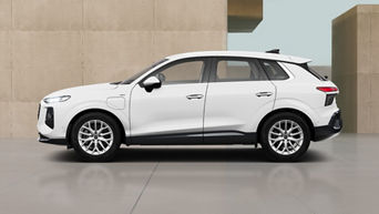Side view of a white Audi Q3 SUV e-hybrid, parked indoors against a beige concrete wall background.