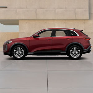 A red Q5 SUV e-hybrid parked against a textured beige backdrop, showcasing its modern design and sporty features from a side view.