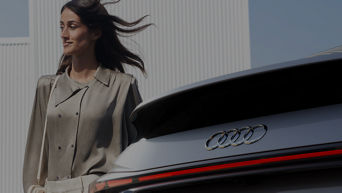 Woman posing close to the rear of an Audi vehicle