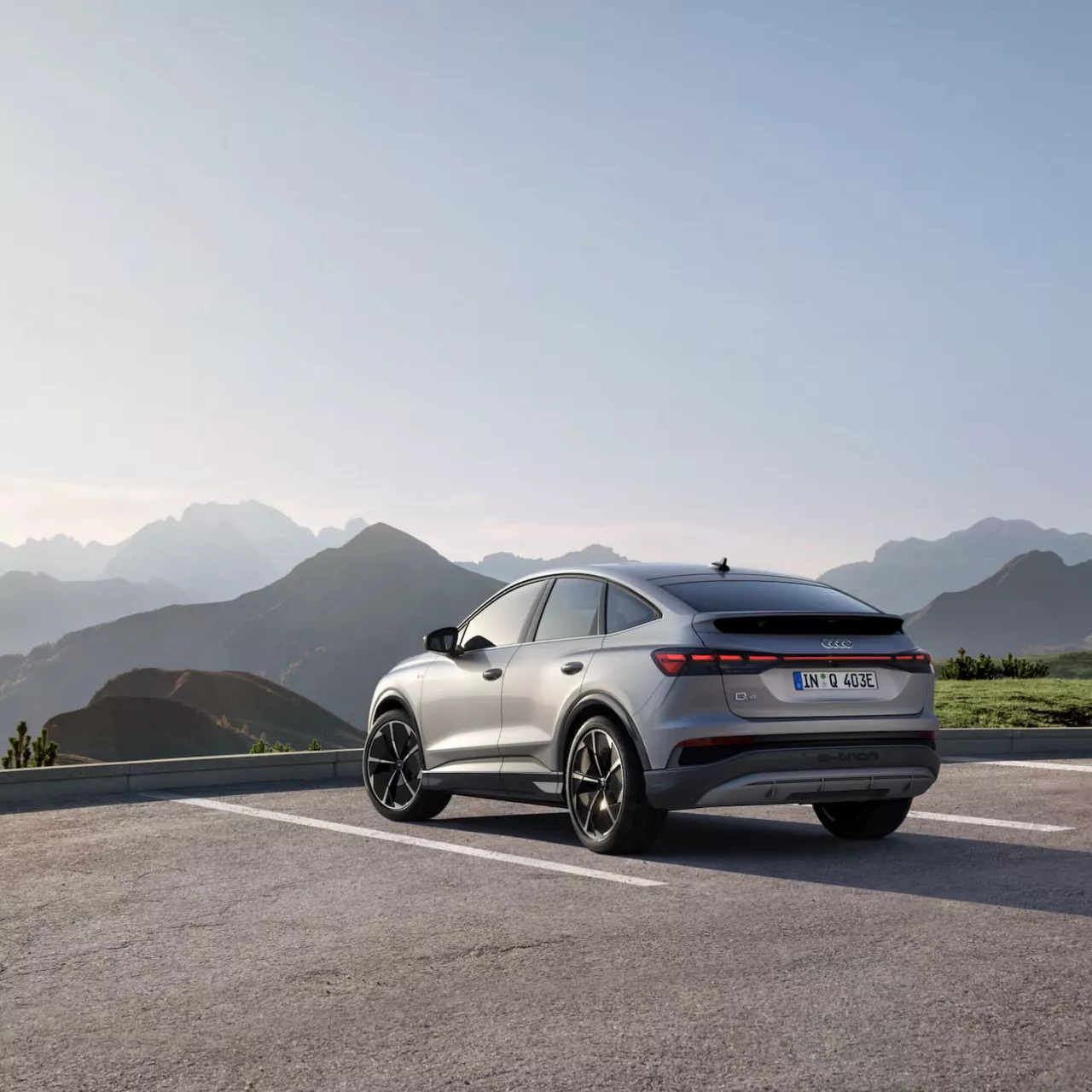 Light grey Audi Q4 parked by the mountains