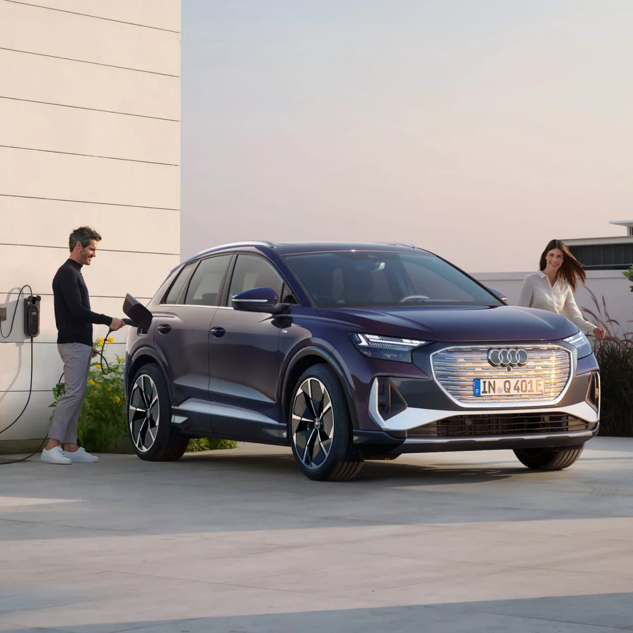 Couple charging an Audi Q4 e-tron outside