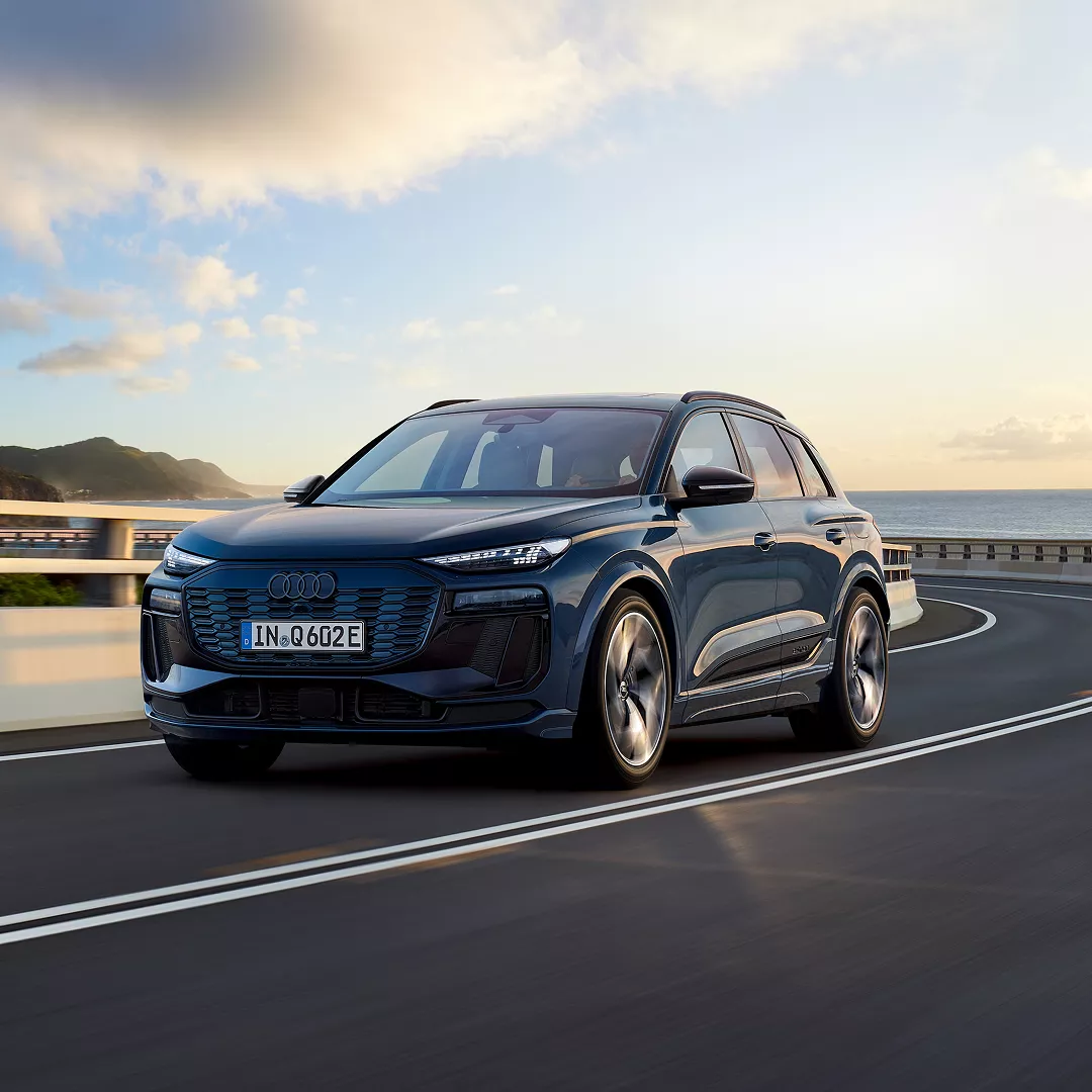 A blue Q6 SUV in motion on the road