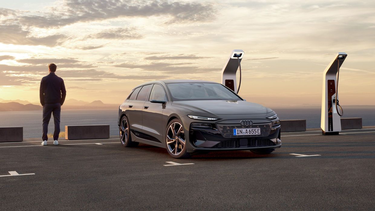 Audi car in the sunset, with a man and electric chargers in the background