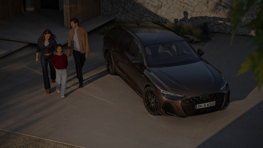 A young couple walking away from a parked Audi Q4 e-tron car