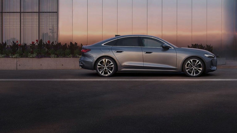 Chrome Audi infront of modern office building with a gradient sunset reflection