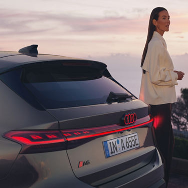 Close-up of an Audi A6 Avant e-tron performance rear with distinctive LED taillights, at dusk.