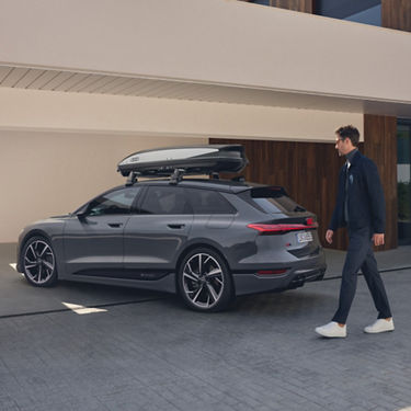 Audi e-tron SUV with roof box parked outside.
