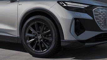 Close-up of an Audi's wheel and fender, featuring sleek black alloy wheels.