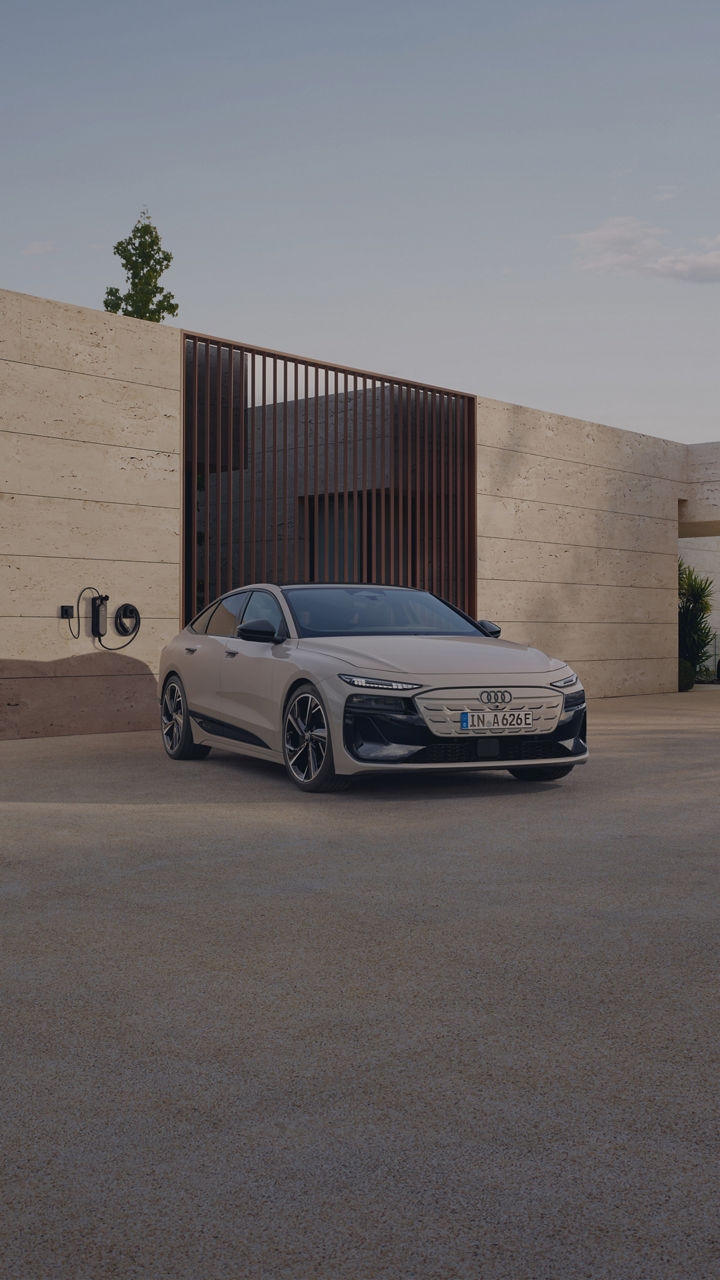 Audi A6 Sportback e-tron parked near a EV wall charger in modern settings.