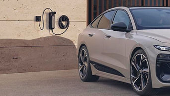 A sleek electric car parked beside a wall-mounted charging station, set against a minimalist contemporary backdrop.