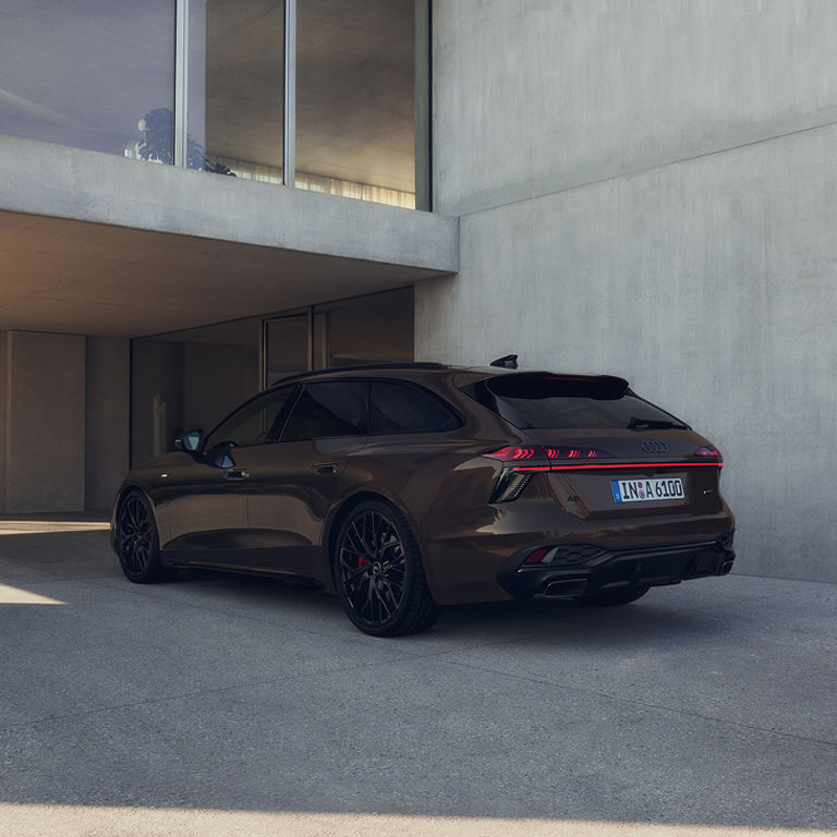 A parked brown Audi car in a modern concrete building