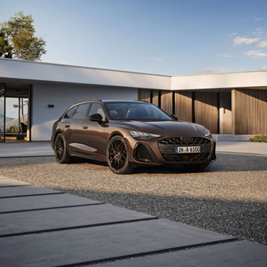 Brown Audi A6 Avant parked in front of a modern house