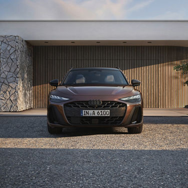 Front view of a brown Audi A6 Avant parked in front of a modern house