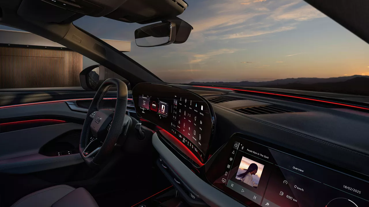 Interior of an Audi from the passenger seat and sunset seen from the windshield outside