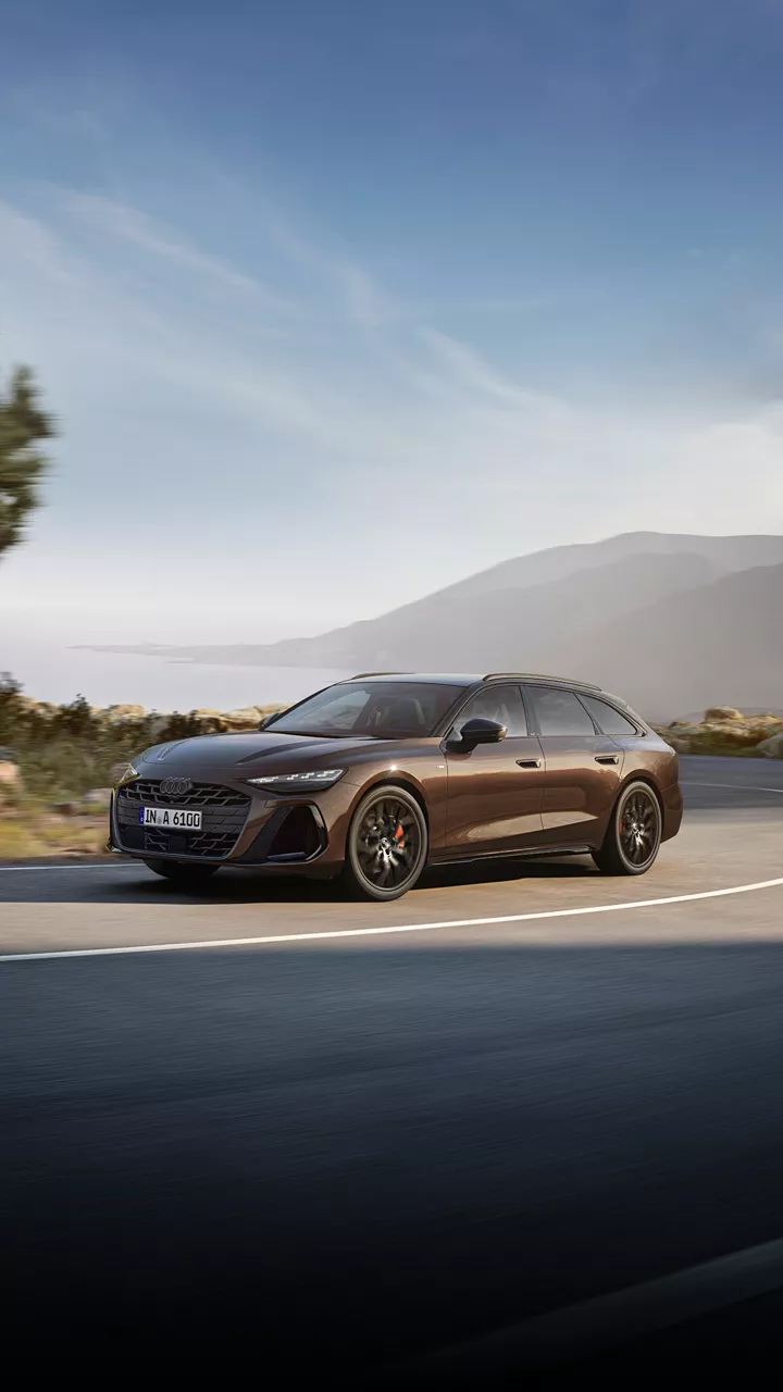A brown Audi A6 Avant in action driving downhill on a mountain road
