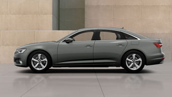A6 Saloon TFSI e parked beside a beige stone modern building