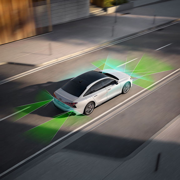 An Audi car on a city street, with green and blue light beams depicting advanced sensor technology for enhanced driving safety.