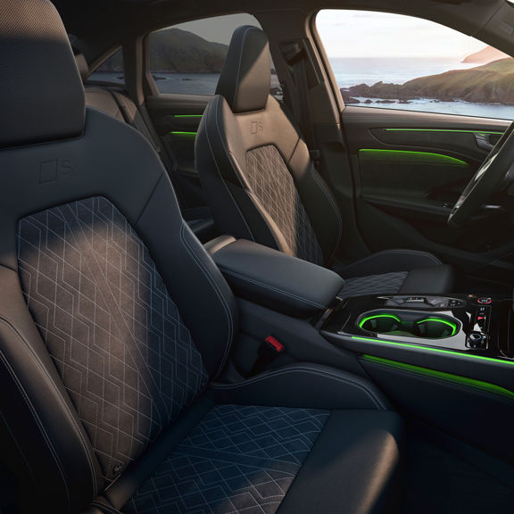 Audi A6 Saloon e-hybrid car interior featuring stylish black seats with quilted patterns, green accents, and modern console design.