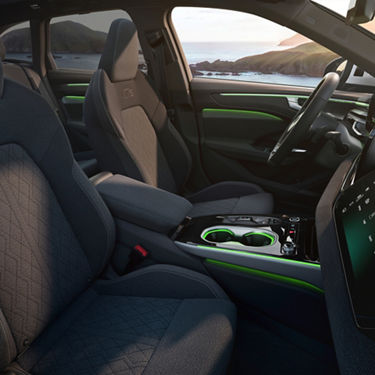 Interior of a modern car featuring comfortable seats, a sleek dashboard with a digital display, and stylish green accents.