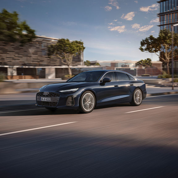 Blue Audi A6 Saloon in motion on an urban street