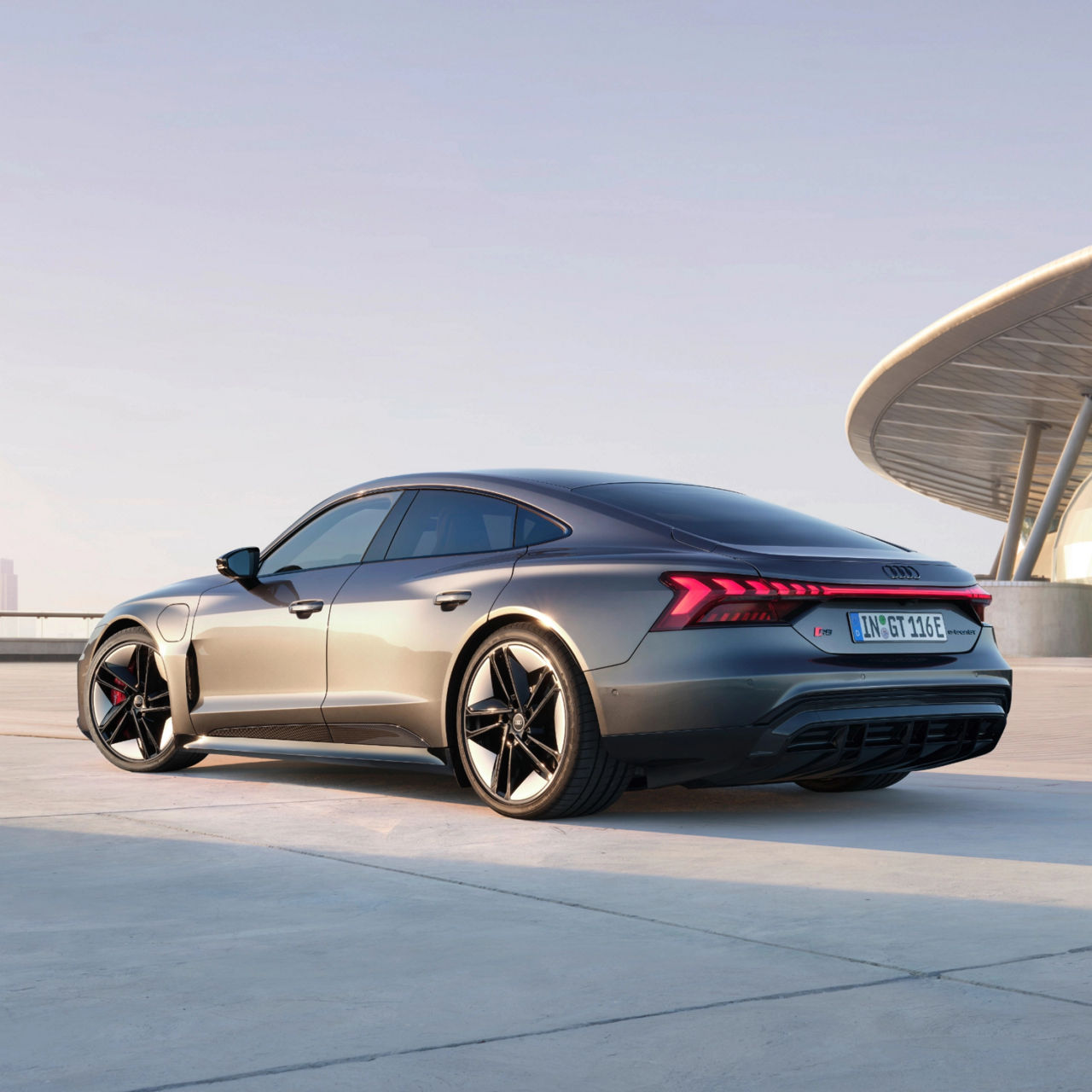 Audi electric sedan on a rooftop, modern design, at dusk.