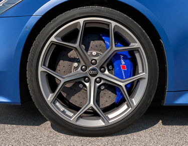 Blue car's wheel with brake calliper and logo visible on the rim.