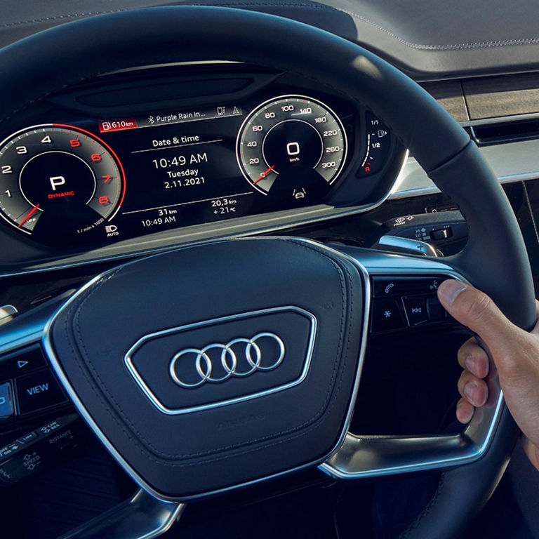 Car dashboard with digital speedometer and multimedia touchscreen display.