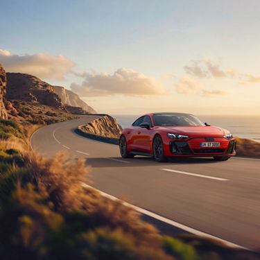 Red Audi e-tron GT quattro cruising on a curvy coastal road