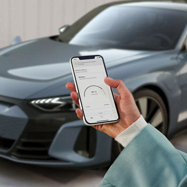 A woman's hand holding a phone while browsing myAudi app
