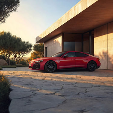 Red Audi e-tron GT quattro left side view while parked in front of a house