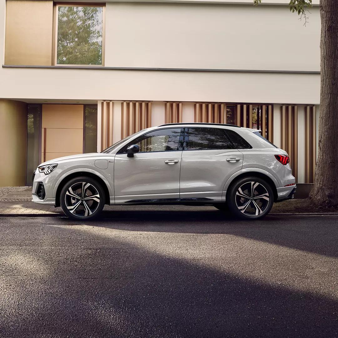 A white SUV parked on a tree-lined street, showcasing modern design against a stylish backdrop of muted colours.