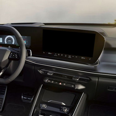 Car interior showcasing a modern dashboard with a large central touchscreen, steering wheel, and control buttons.