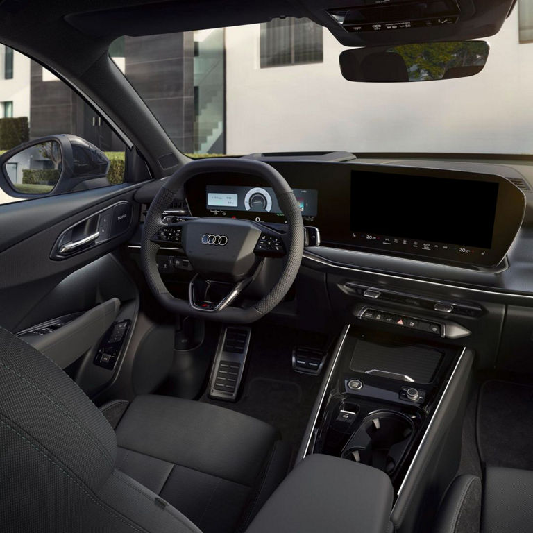 Interior of an Audi car featuring a sleek dashboard, modern steering wheel with controls, and sophisticated touch screen display.