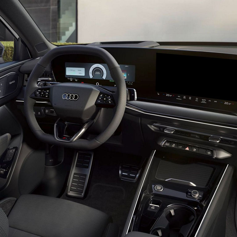 Interior view of an Audi car showcasing a sleek dashboard, a modern steering wheel, and multiple digital display screens.