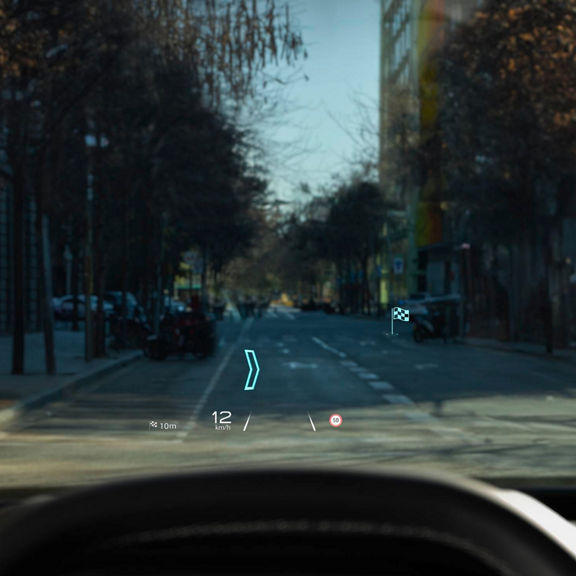 Audi Q3 head-up display showing speed, navigation, and distance info projected onto the windshield of city street view.