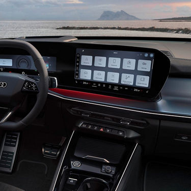 Car interior showcasing a modern dashboard with a large central touchscreen, steering wheel, and control buttons.