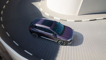 Areal shot of an Audi Q4 e-tron travelling down a spiral road