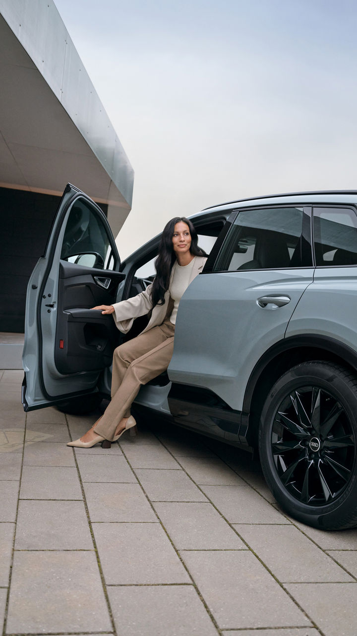 A woman getting out of an Audi Q4 e-tron