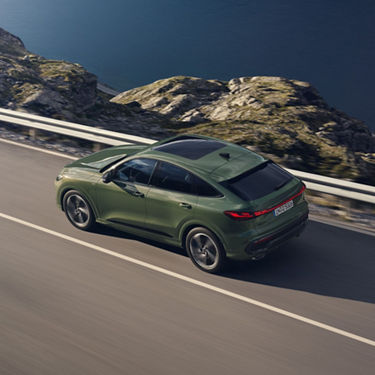 Green Audi SUV driving outdoors, top-down aerial view.