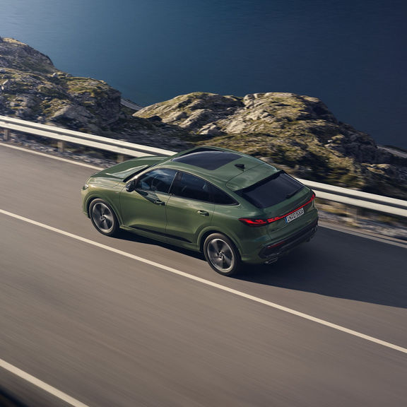 A blue car parked in front of steps during daytime.