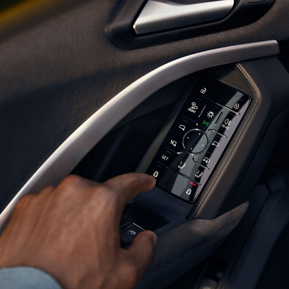 Male hand interacting with a smart door panel featured in selected Audi Vehicles.