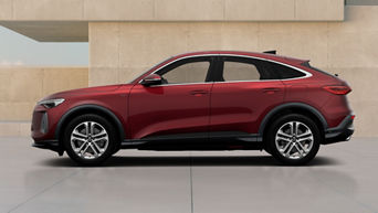A red Q5 Sportback e-hybrid parked in a modern, minimalist space with beige concrete walls and smooth flooring.