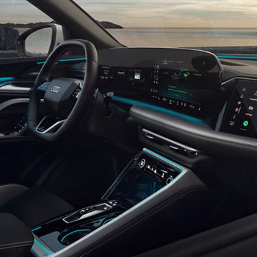 Sleek interior of an Audi car featuring a modern dashboard with digital displays, a stylish steering wheel, and ambient lighting.