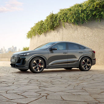 A silver Q6 Sporback e-tron parked in a cobbled pavement